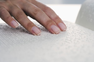 mano leyendo una página en braille
