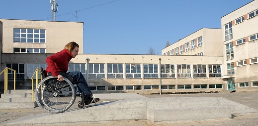 persona en silla de ruedas subiendo rampa, elemento de accesibilidad universal