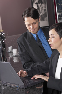 Dos personas en una oficina mirando algo en un ordenador los recursos al emprendimiento