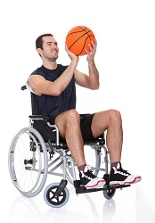 Un joven en silla de ruedas jugando al baloncesto