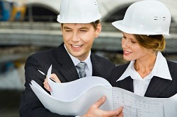 Dos arquitectos con planos de una vivienda
