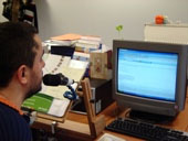 Usuario con su micrófono conectado al ordenador utilizando el programa de voz Dragon Speak como producto de apoyo