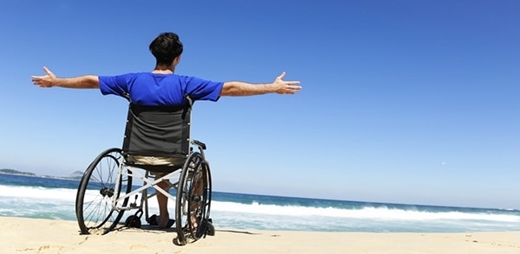 Fotografía de una persona en silla de ruedas frente al mar - Taller de autocuidado emocional para personas con ELA