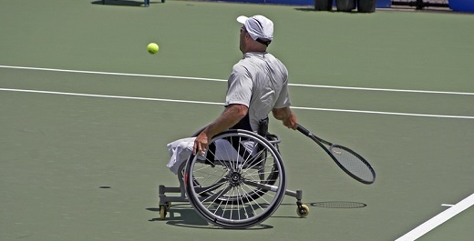 persona en silla de ruedas jugando al tenis y compartiendo beneficios del deporte