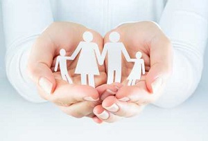 manos que recogen siluetas de papel de una familia