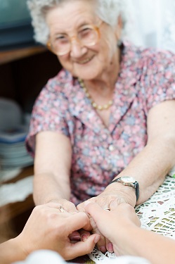 mujer mayor sonriendo y extendiendo sus manos en el día mundial del alzheimer 2019