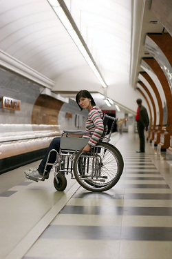 chica en silla de ruedas en el anden esperando el Metro