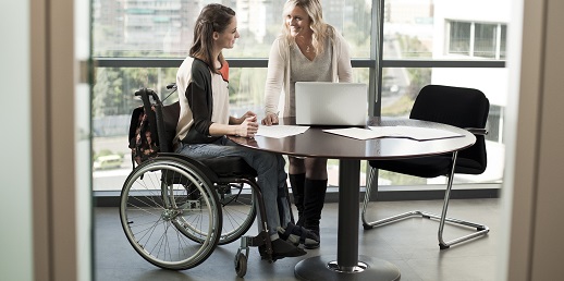 chica en silla de ruedas y su compañera, discapacidad en las empresas