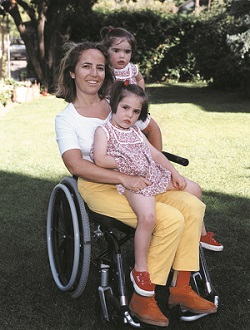 embarazo en mujeres con discapacidad, mujer en silla de ruedas con dos niñas