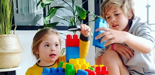 Marieta jugando con su hermano mientras sus padres teletrabajan