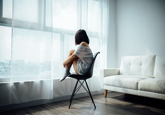 chica sentada mirando por la ventana