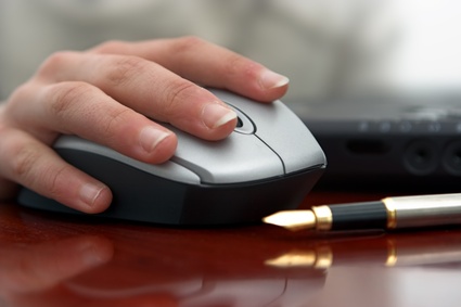 Una mano de un hombre usando un ratón de ordenador. Política de Privacidad en Discapnet