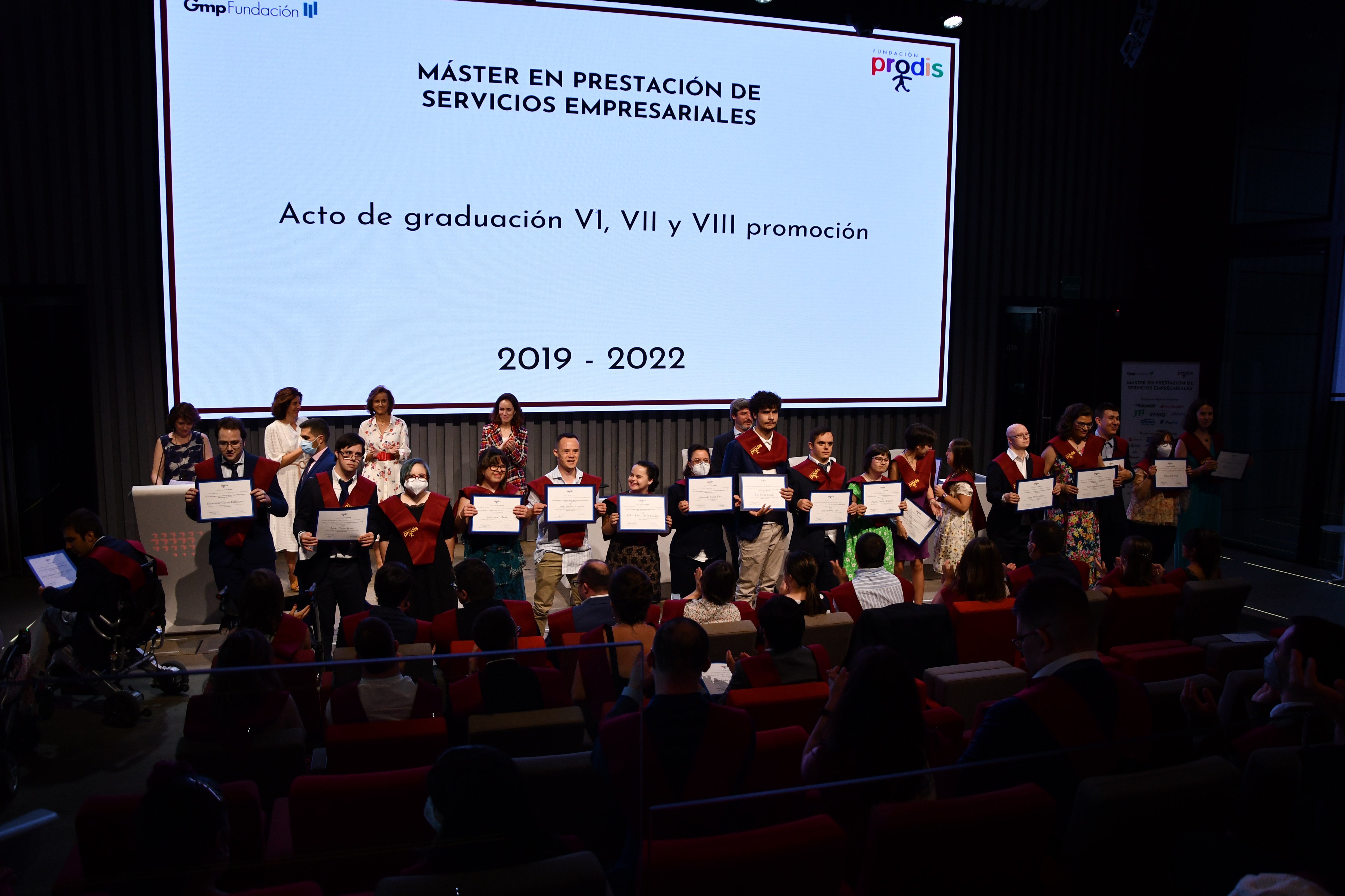 Alumnos en el acto de graduación con su diploma