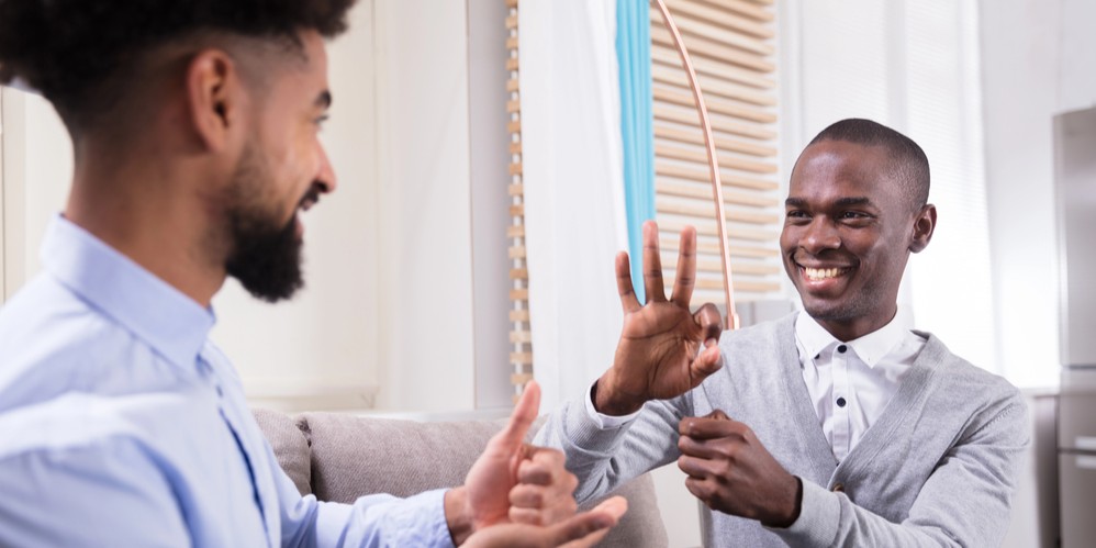 Dos personas sordas entablando una conversación en lenguaje de signos
