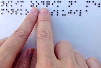 Visuales. Persona ciega usando el sistema de lectura braille