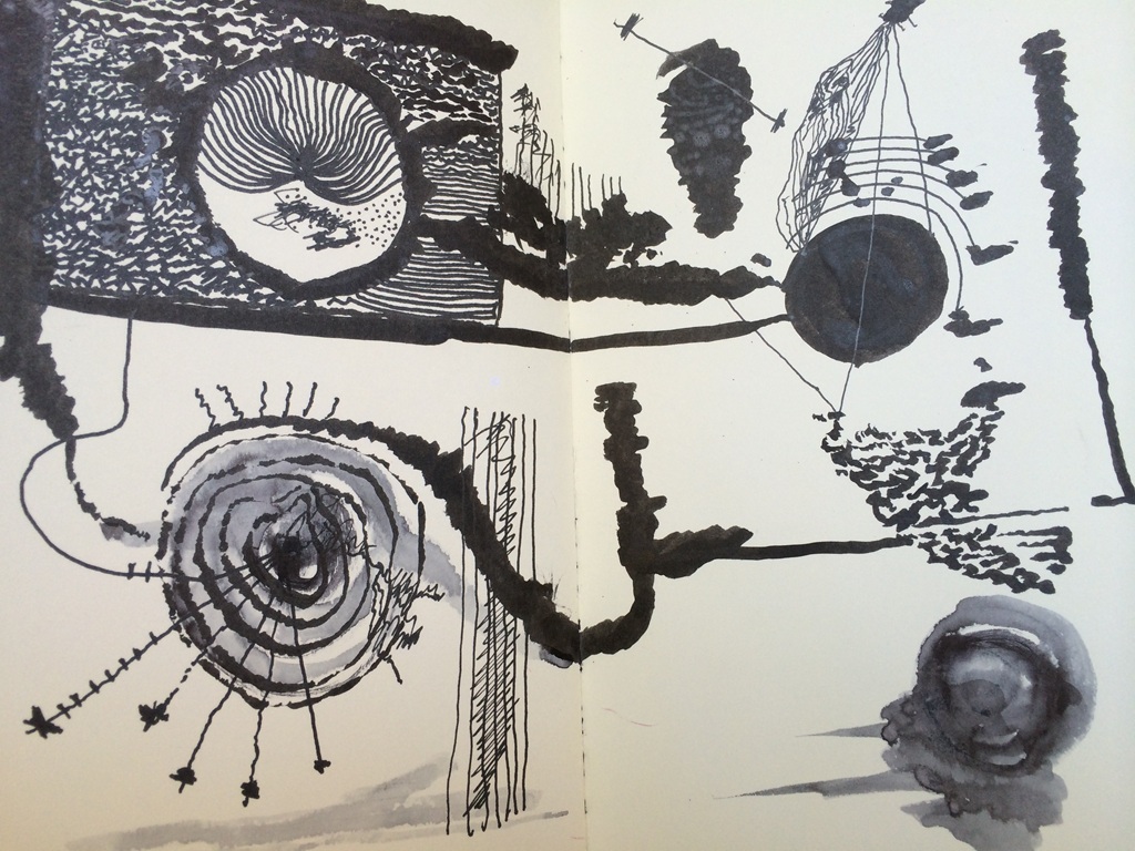 Ilustración abstracta en tinta negra y aguada gris sobre papel blanco de un cuaderno abierto. La composición combina formas orgánicas y geométricas: un círculo con líneas concéntricas en la parte inferior izquierda, un gran círculo oscuro en la zona superior derecha y varios trazos gruesos, manchas irregulares y líneas finas que conectan los elementos. En la parte superior izquierda aparece una forma semicircular con líneas radiales dentro de un marco texturizado. El dibujo presenta un estilo gestual y experimental, con contrastes marcados entre negro intenso y grises diluidos.