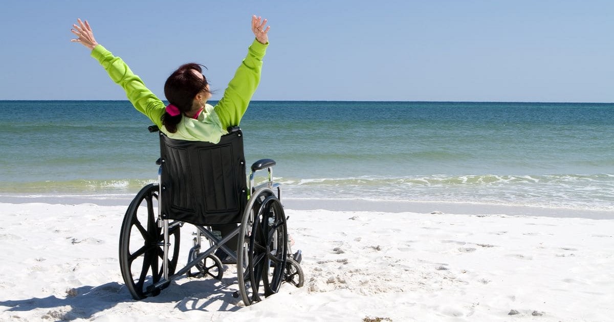 Una persona en silla de ruedas disfrutando de una playa (Fuente: Tododisca)