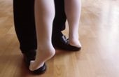 Una persona joven bailando encima de los pies de su profesor