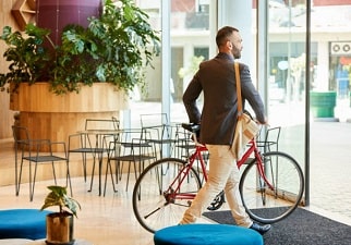 Un chico vestido con traje haciendo caso a la ESG, usa como transporte la bicicleta