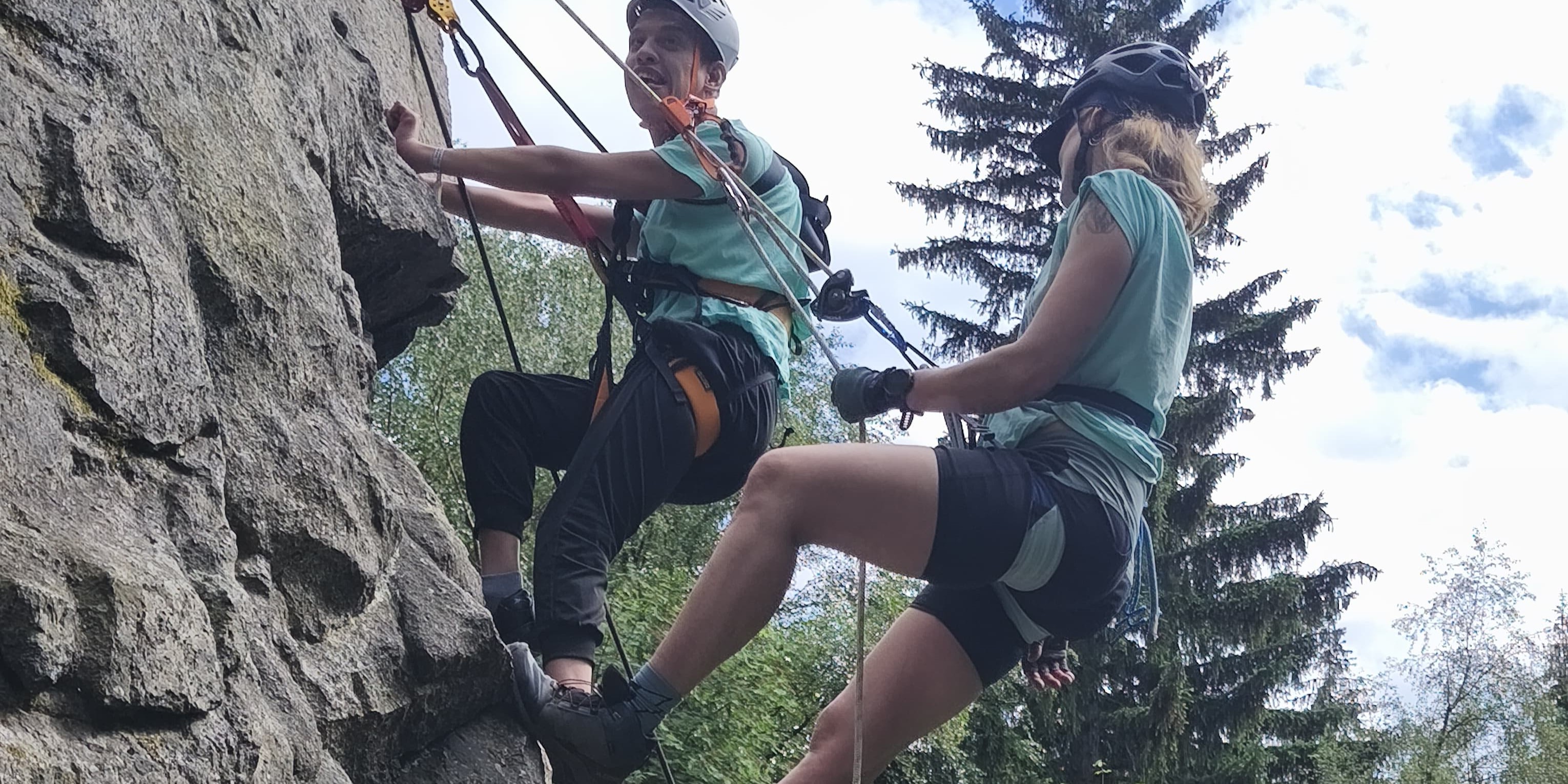 Kenjy junto a una monitora haciendo escalada en una montaña