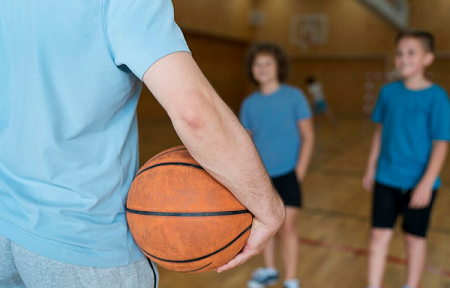 niños esperando a jugar al baloncesto hasta que el arbitro les de el balón