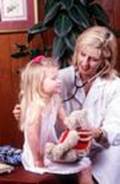 Doctora revisando a una niña con cáncer