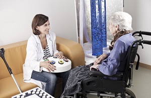Una doctora y cuidadora atiende a una mujer de edad avanzada en silla de ruedas