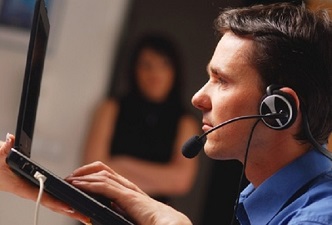 Un joven con discapacidad visual en su puesto de trabajo y con un ordenador
