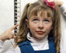 Niña tomándose la altura de su crecimiento, una forma de educar en salud