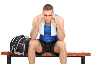 Un joven deportista sentado en un banco pensativo. Deporte y salud mental
