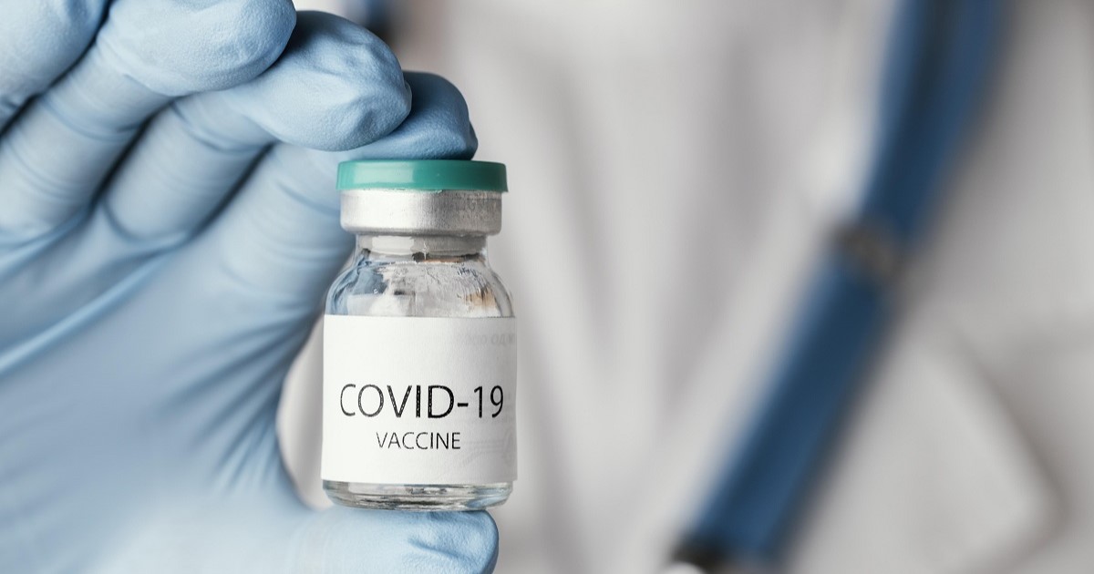 mano de un supuesto doctor sujetando un bote donde se encuentra la vacuna del covid-19