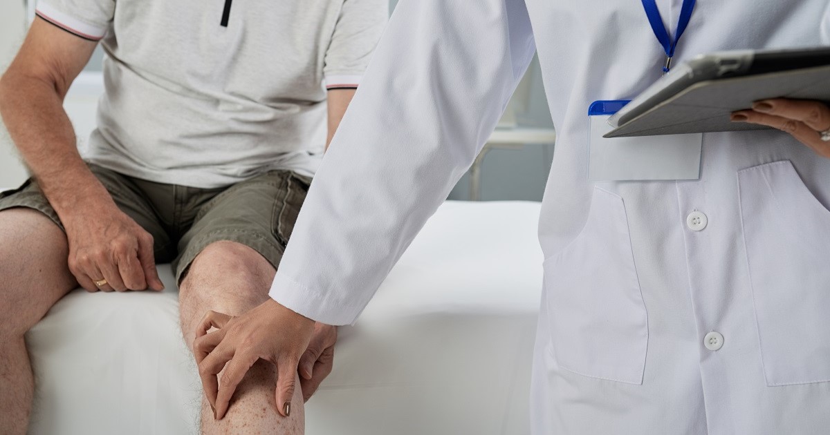 Doctor toca la pierna de un paciente posiblemente para identificar alguna enfermedad Musculoesquelética