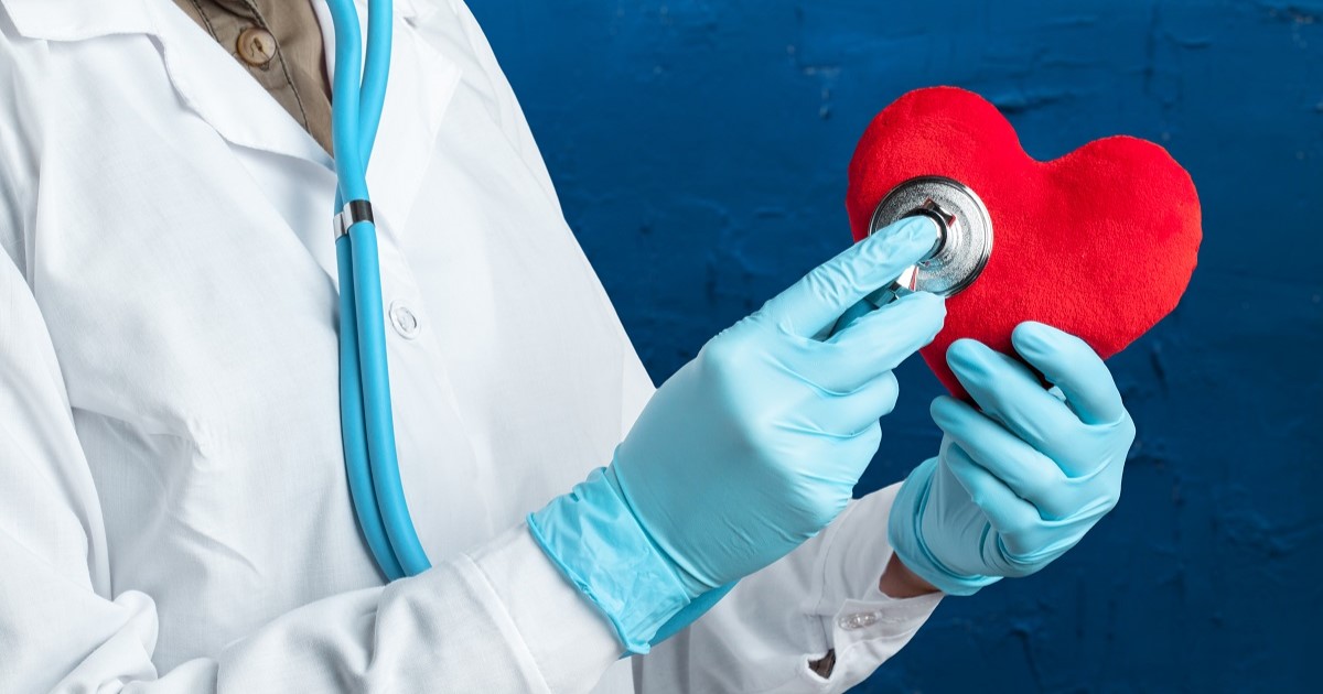 doctora comprobando los latidos de una figura de un corazón. Esta imágen representa como la doctora trata las enfermedades cardiovasculares