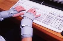 Una persona con las manos vendadas por la esclerosis lateral amiatrofica usando un teclado de ordenador