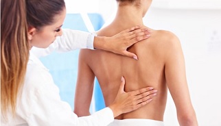 Una persona tratándose de una de las enfermedades reumáticas de espalda