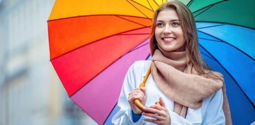 chica con un paraguas multicolor, con muchas emociones