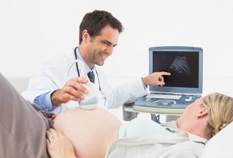 Un médico haciendo una ecografía a una mujer ebarazada