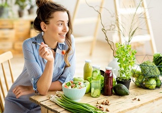Chica comiendo vegetales, uno de los hábitos de vida saludables que debemos hacer todos