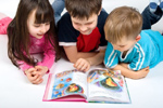 Niños de infantil y primaria leyendo un libro