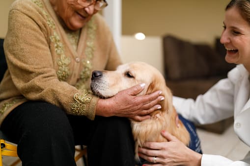 Mujer y cuidador con perro de terapia