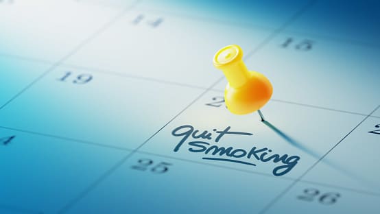 Calendario marcado con una chincheta, que pone quit smoking
