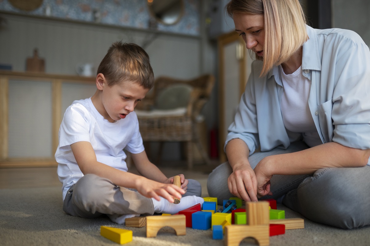 madre jugando su niño con discapacidad cognitiva