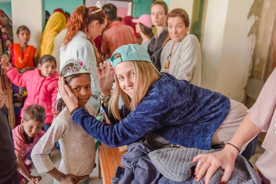 Voluntaria poniendo una corona a una niña India