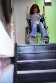 Mujer en silla de ruedas enfadada frente a una escalera y provocando una de las situaciones de conflicto
