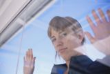 Cuidarme yo. Mujer apoyada en el cristal de una ventana