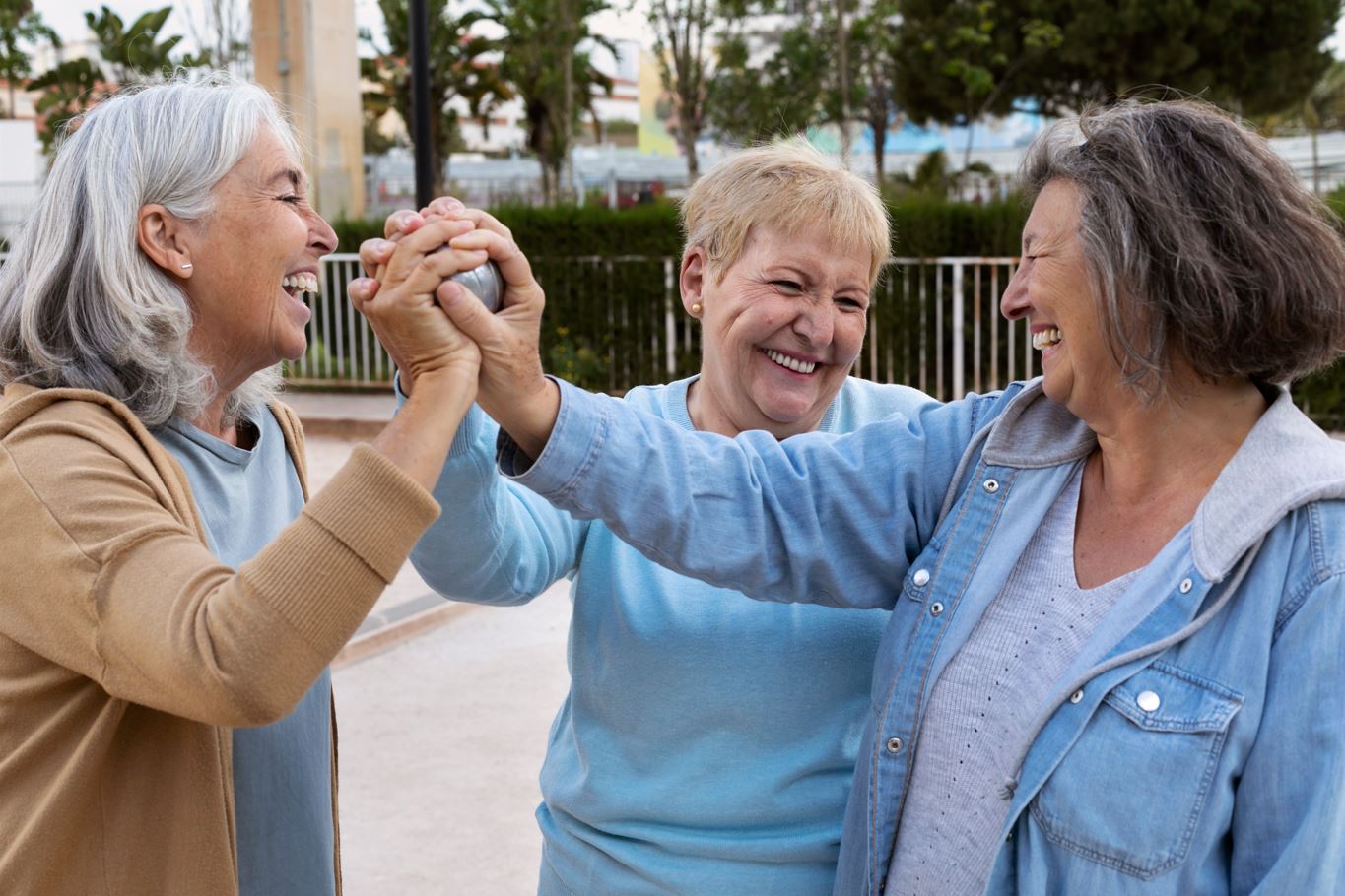 tres mujeres mayores dandose la mano. representan la unidad de una comunidad de Cohousing senior