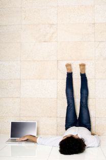 Un joven tumbado en el suelo con síndrome de piernas inquietas