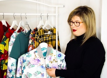 Paola Torres mirando unos percheros de ropa