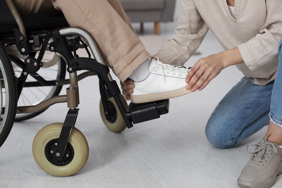 persona con dependencia aparece como le ayudan a calzarse
