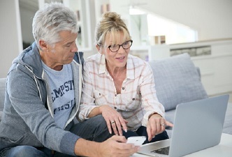 Una pareja de mayores mirando algo en un ordenador. Salud y mujer